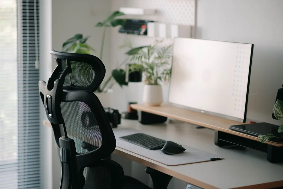 Bureau à domicile propre et bien rangé avec des produits de nettoyage, des papiers et des paniers de rangement.